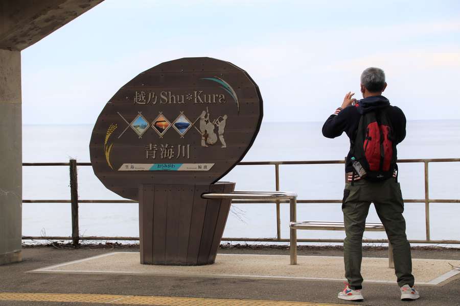越乃Shu＊Kuraの装飾駅名標を撮影する男性