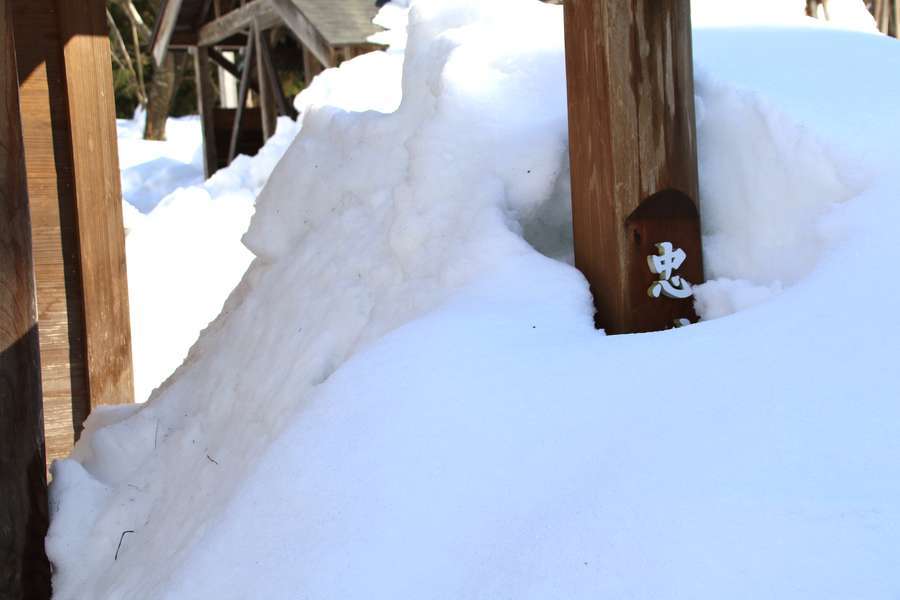 雪に埋もれた忠犬しろ神社標柱